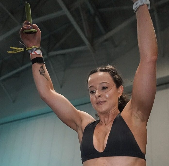 Alana with both arms raised after finishing a station during her HYROX race